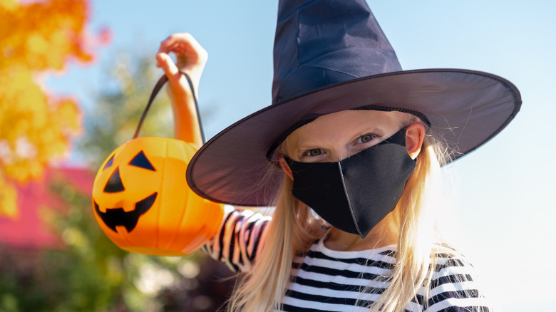 Girl wearing mask with witch costume