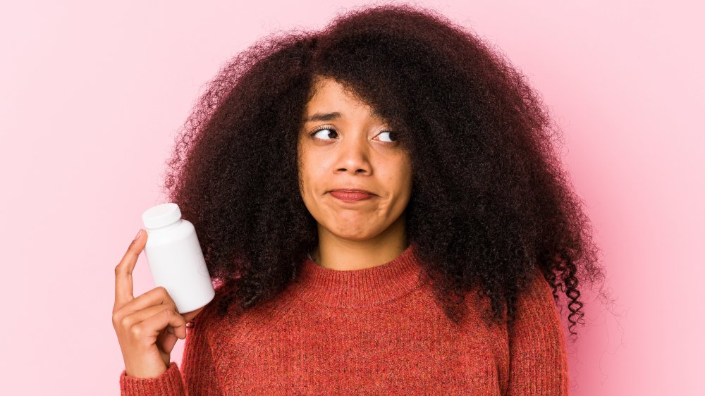 woman holding medication bottle