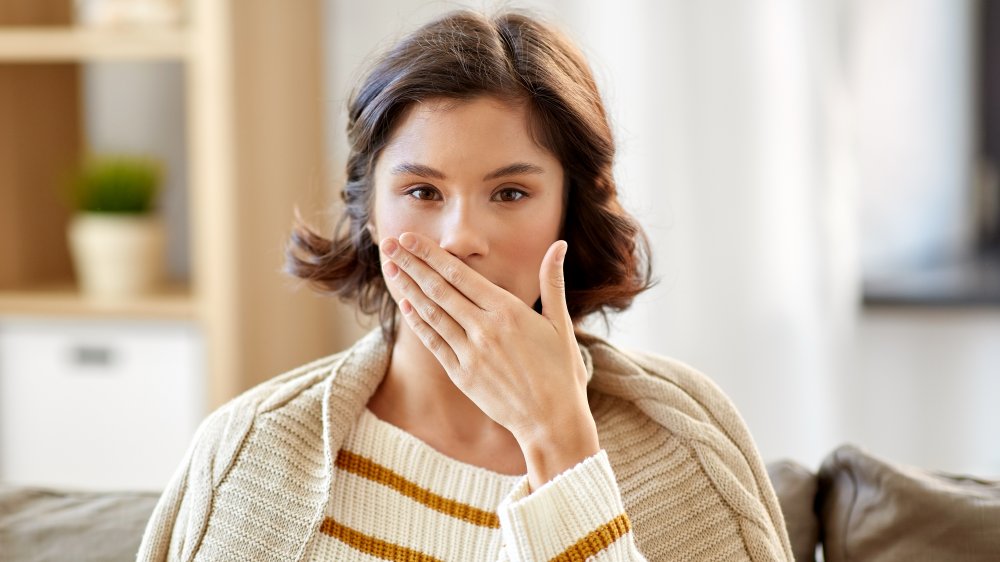 woman covering mouth and tongue