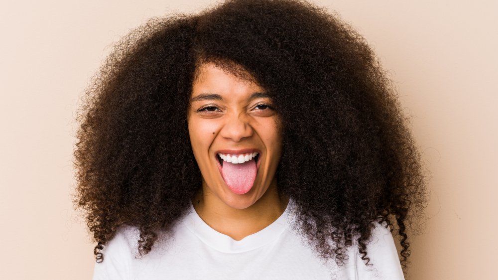 woman sticking out healthy pink tongue