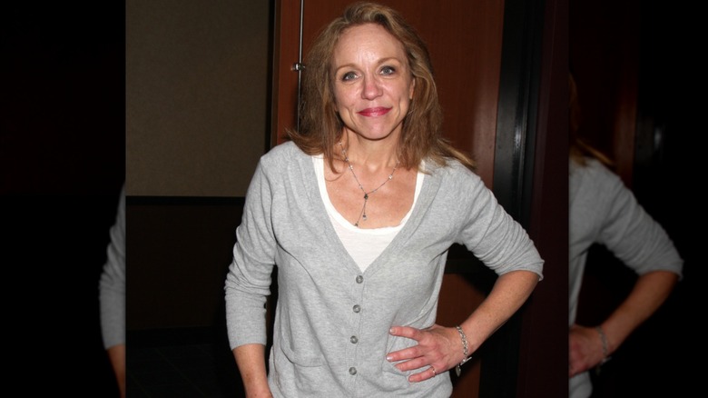 brett butler smiling wearing gray cardigan