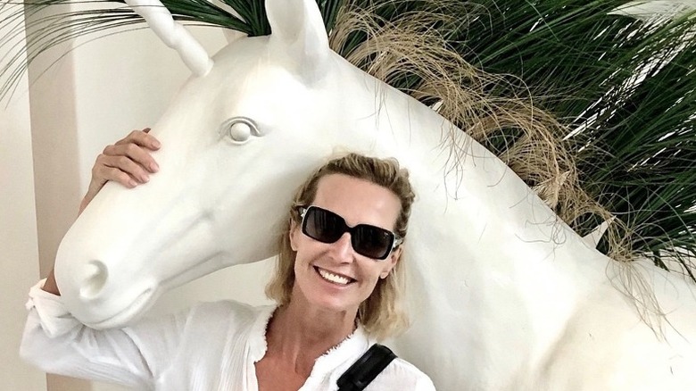 Candice Olson embracing white unicorn statue