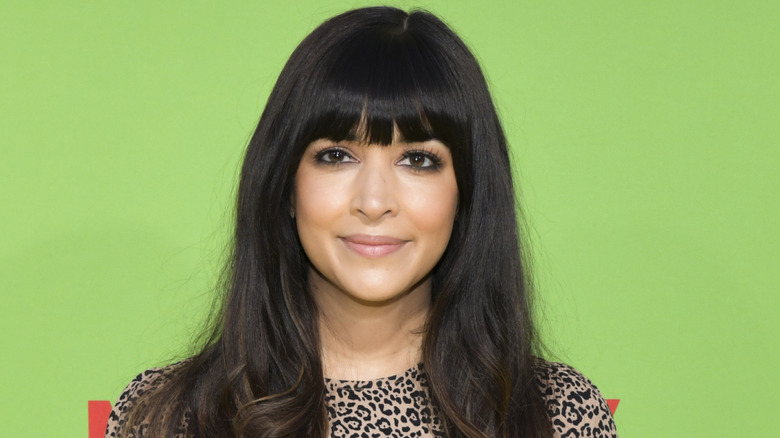 Hannah Simone smiling on step-and-repeat