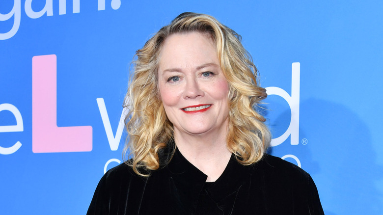 Cybill Shepherd smiling in front of a blue background