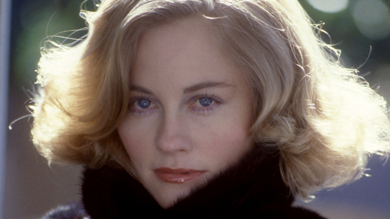 Cybill Shepherd staring into camera wrapped in a coat