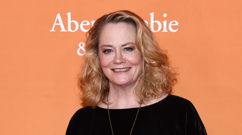 Cybill Shepherd standing against an orange background