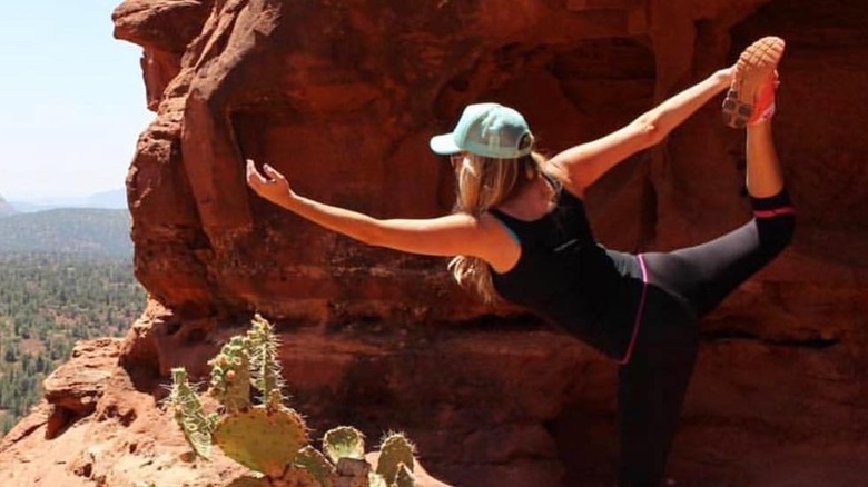 Paige Hemmis doing yoga on a mountain cliff