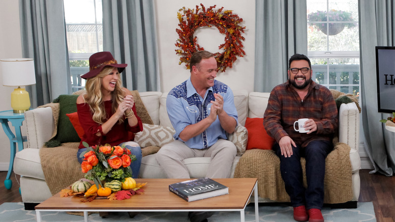 Paige Hemmis laughs and claps her hands on the couch on the set of "Home and Family."