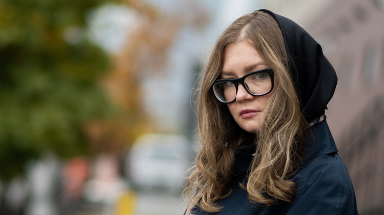 Anna Delvey outside in hood