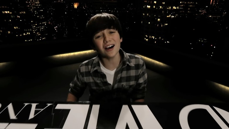 Greyson Chance playing piano on a rooftop at night