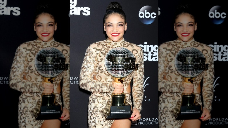 Laurie Hernandez poses with the mirror ball trophy 