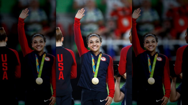 Laurie Hernandez smiling and waving with gold medal 