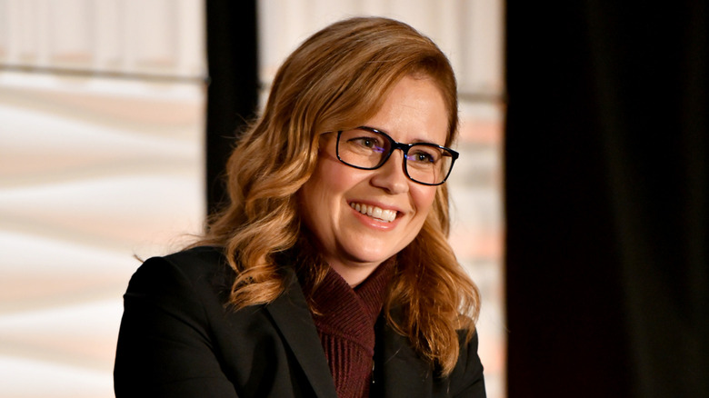 Jenna Fischer smiling on stage at a speaking engagement