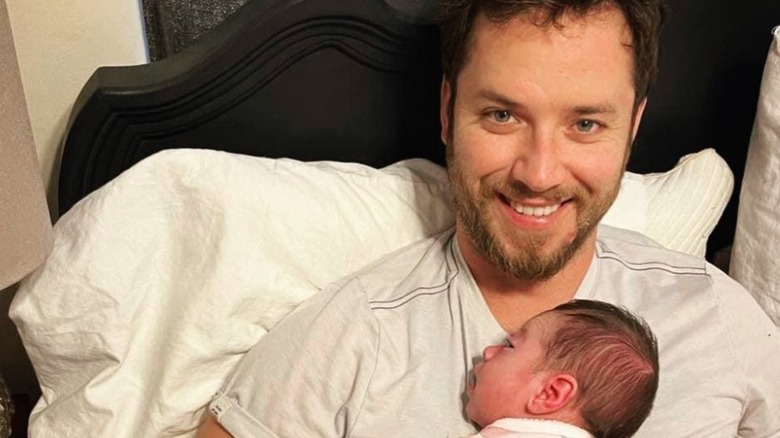 Jeremy Sumpter smiling with his infant daughter