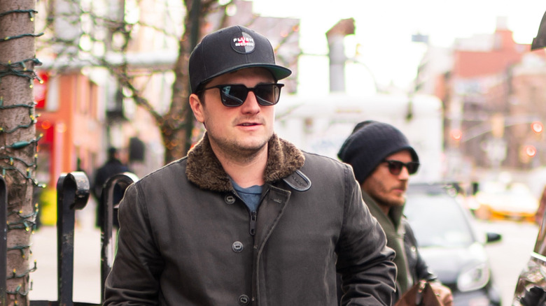 Josh Hutcherson in glasses walking down the street