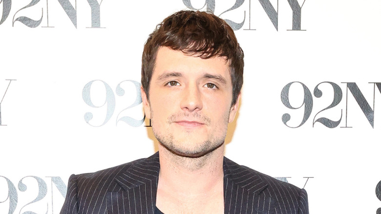 Josh Hutcherson in a black suit at a press event