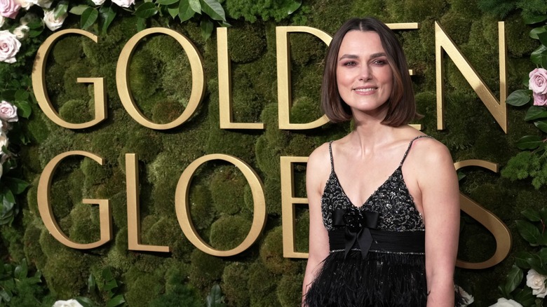 Keira Knightley in front of the floral Golden Globes sign