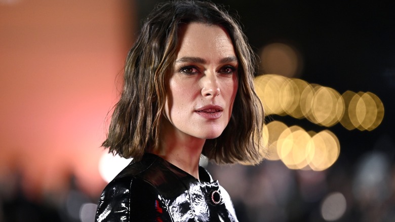 A closeup of Keira Knightley posing in front of lights