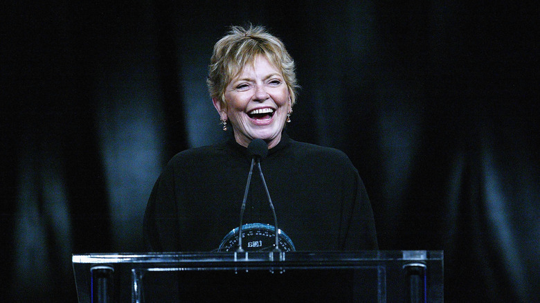 Linda Ellerbee laughing while standing at a podium