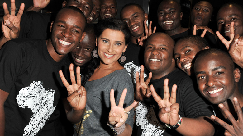 Nelly Furtado posing with a group of teen boys 