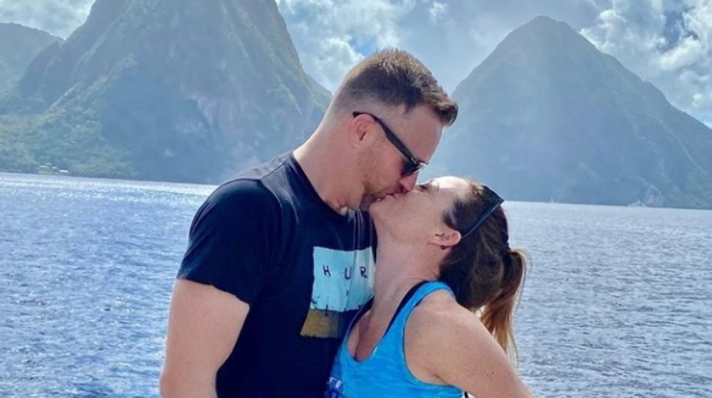 AJ Vollmoeller and Stephanie Sersen kissing in front of mountain range