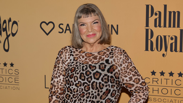 Mindy Cohn smiling and wearing a leopard-print top