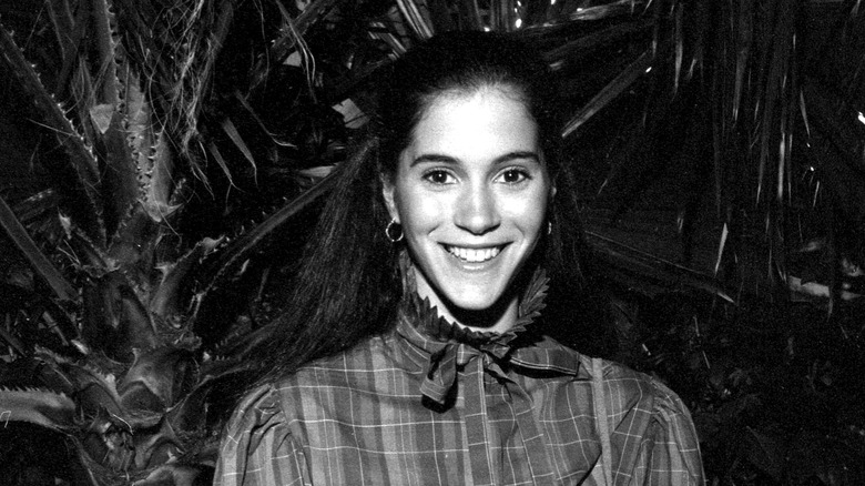 Jami Gertz smiling in black and white