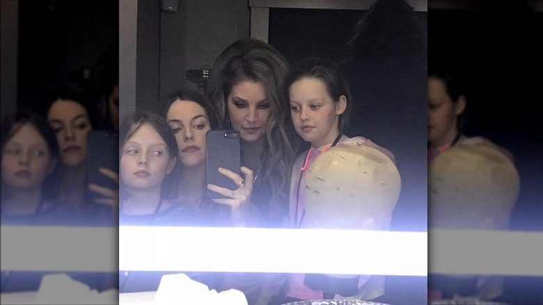 Lisa Marie Presley taking a mirror selfie with daughters, Riley, Finley, and Harper