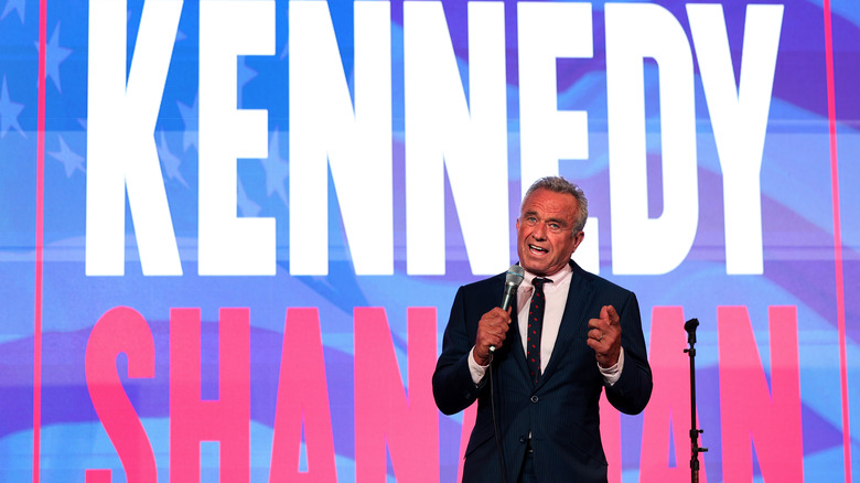 RFK Jr speaking in front of Kennedy Shanahan sign