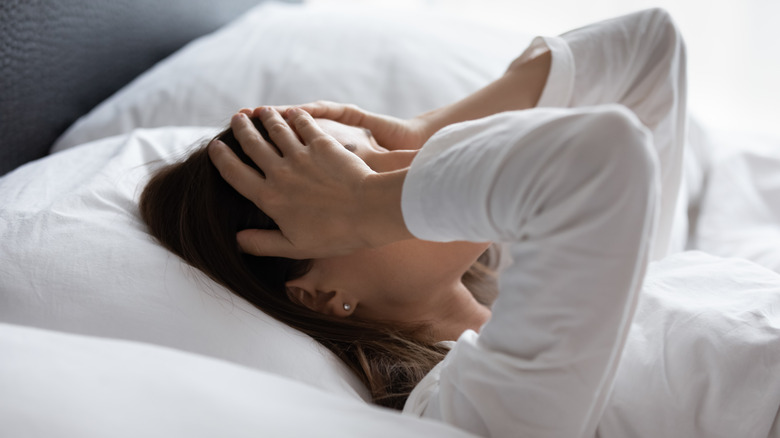 Woman laying in bed with migraine