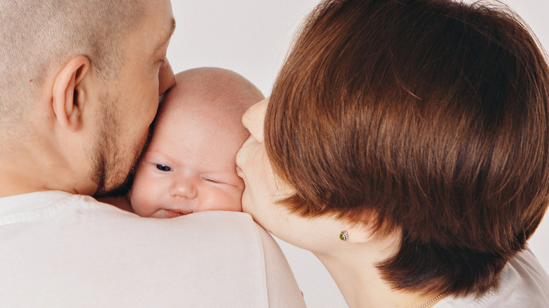 parents kissing baby