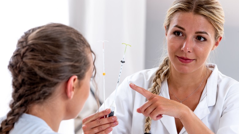 A doctor showing an IUD to a patient 