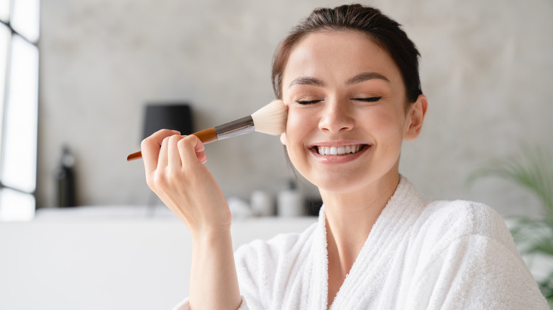 woman putting on powder