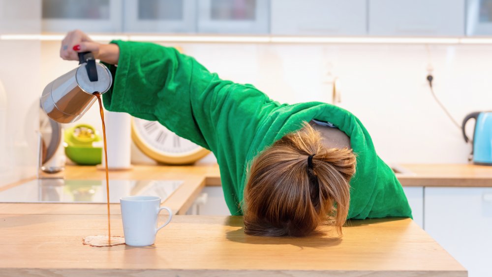 Tired woman pouring coffee