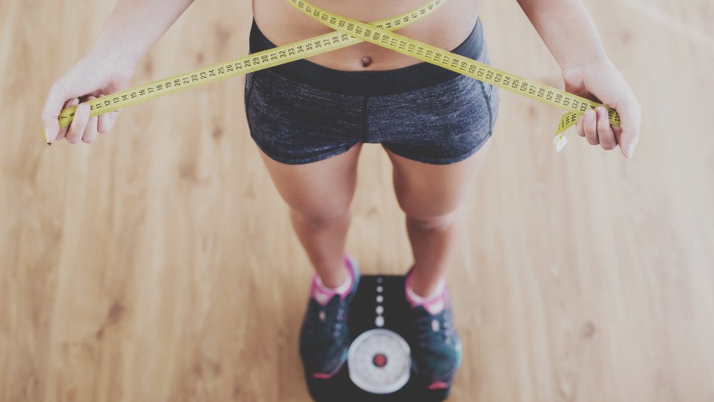 Woman on scale, measuring weight loss