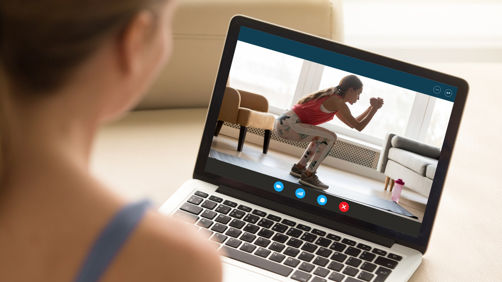 Woman doing squats on laptop