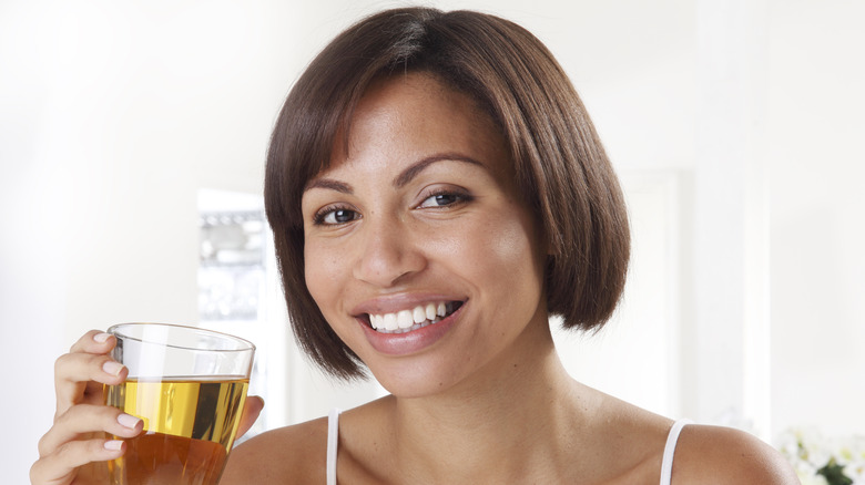 a woman raising a glass of apple juice