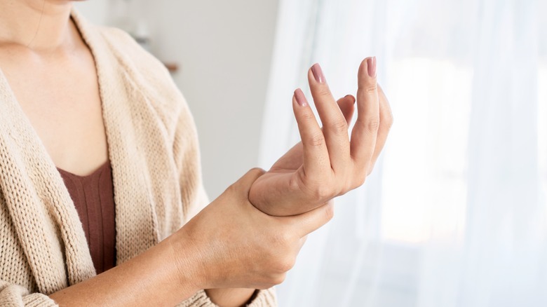 a woman suffering from joint pain in her hand