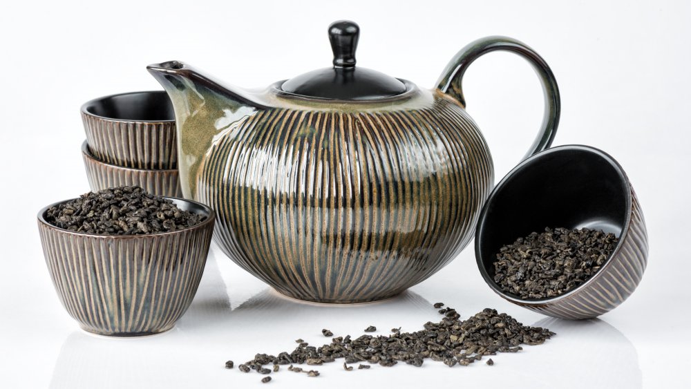 A teapot and cups filled with black tea