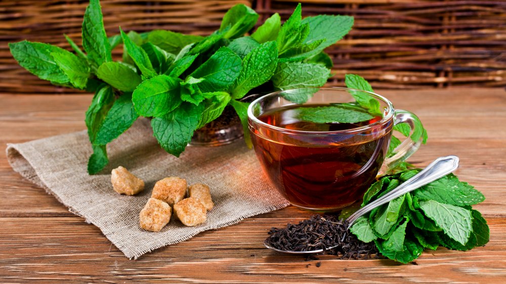 Black tea in a cup with mint and loose tea