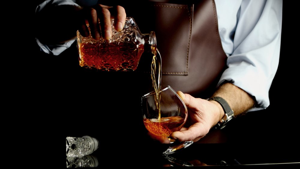 man pouring brandy into a glass