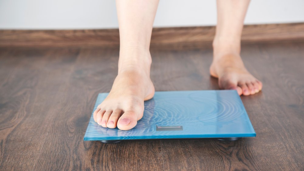 A woman's feet stepping onto a scale