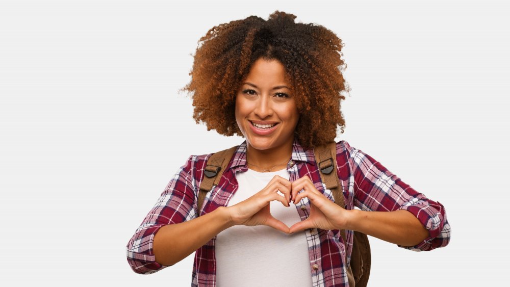 A woman making a heart shape with her hands