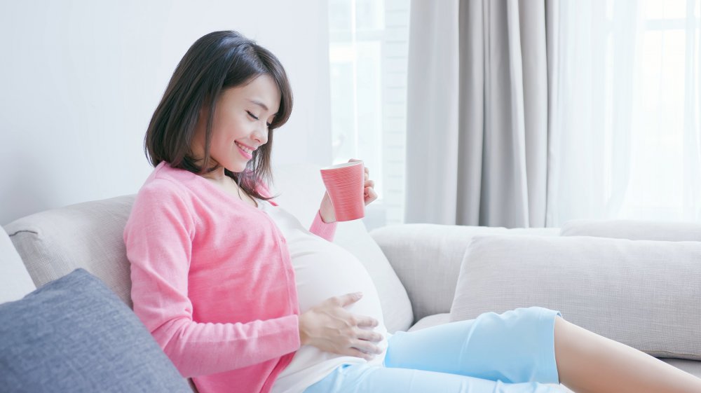 A pregnant woman drinking coffee