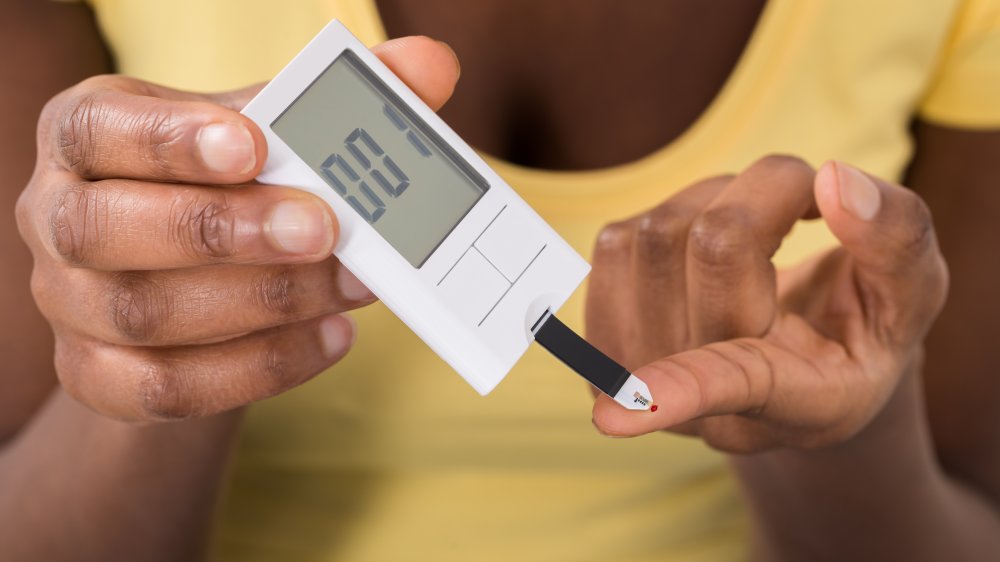 A woman checking her blood sugar, close-up on hands