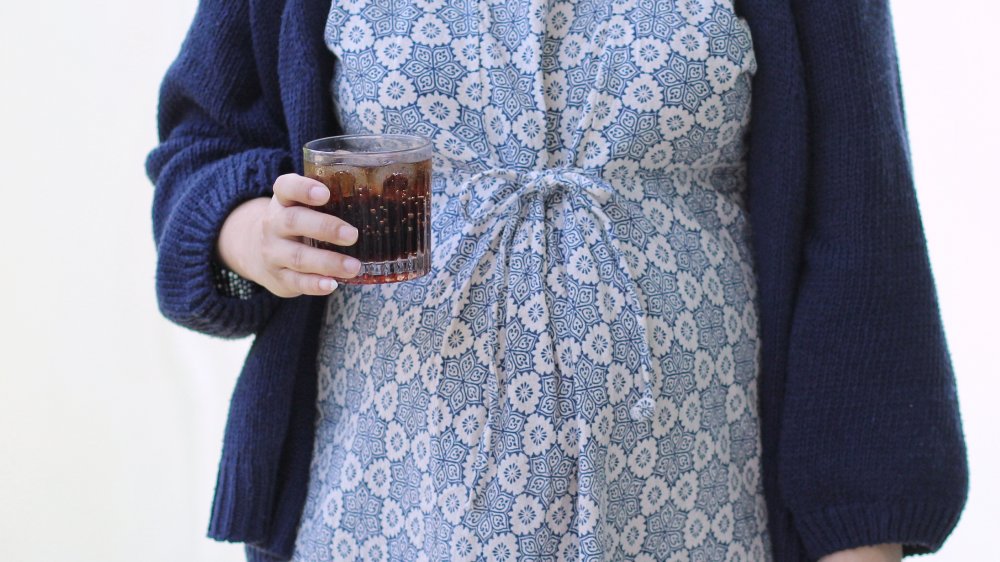 pregnant woman holding diet coke