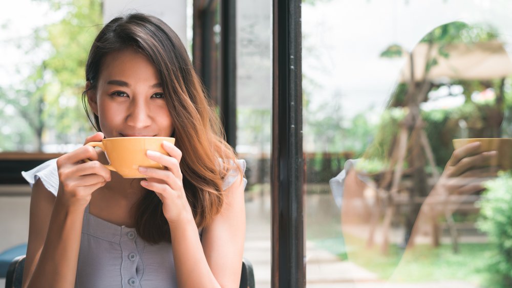 A woman drinking ginger tea in her home