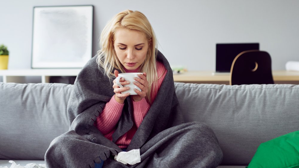 Woman with cold drinking tea