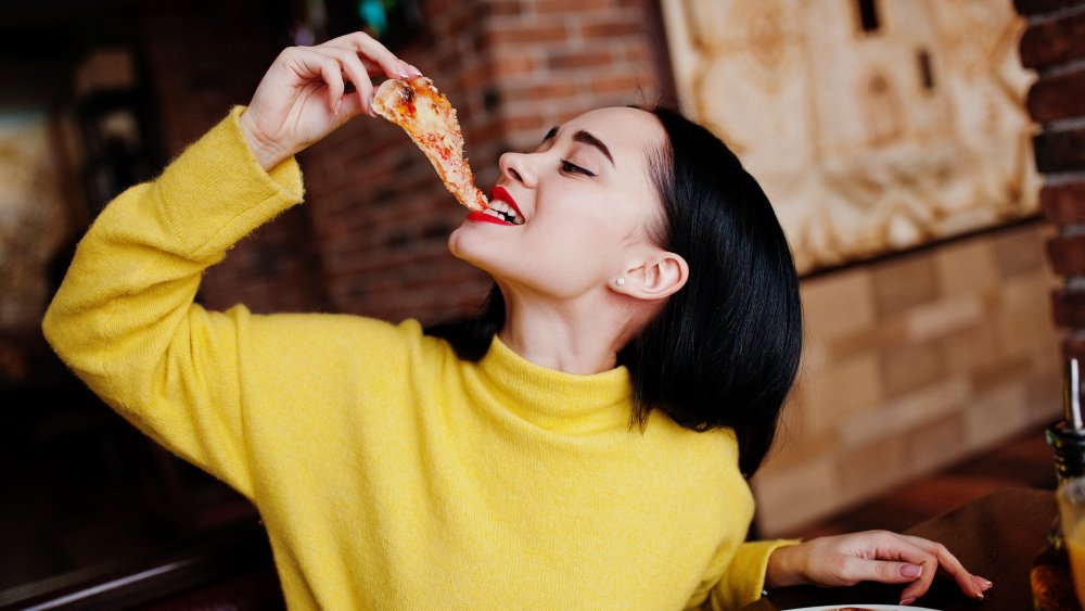 a woman eating a slice of pizza