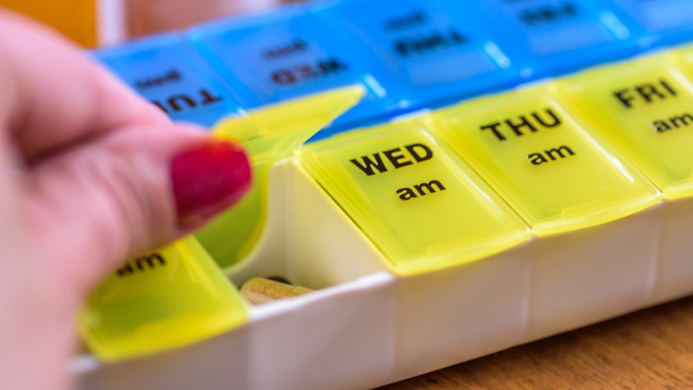 A woman's hand opening a pill box